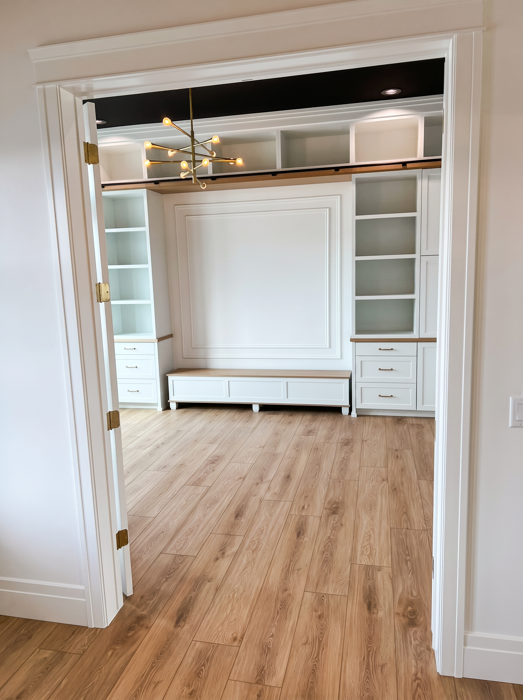 Custom built-in cabinetry and bench with brass chandelier