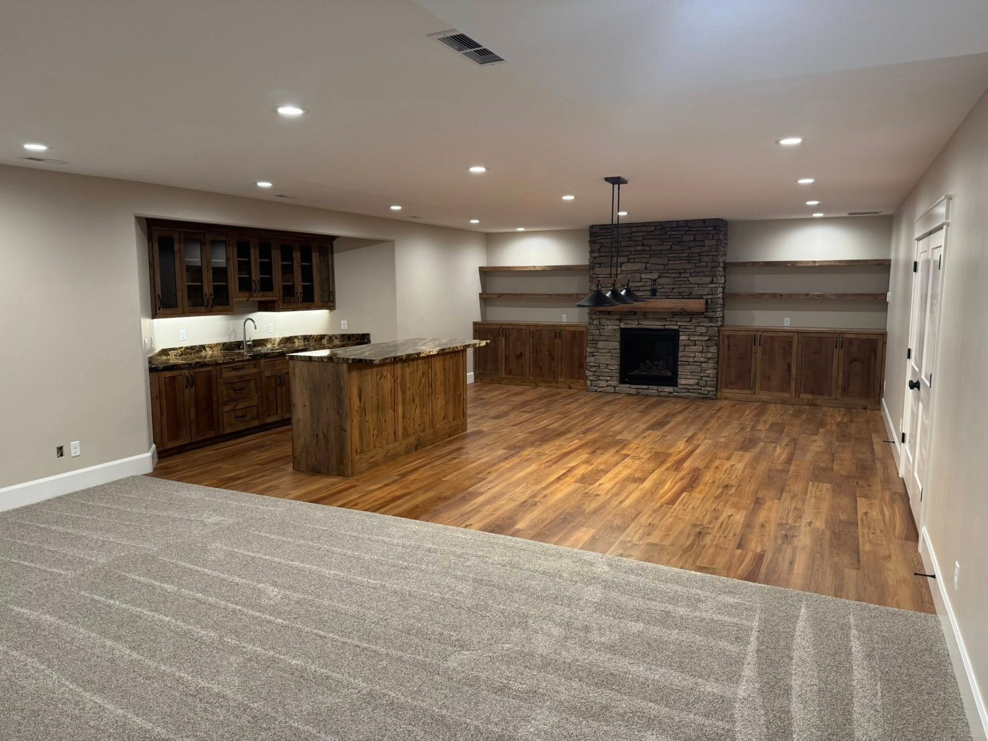 Finished basement family room with stone fireplace