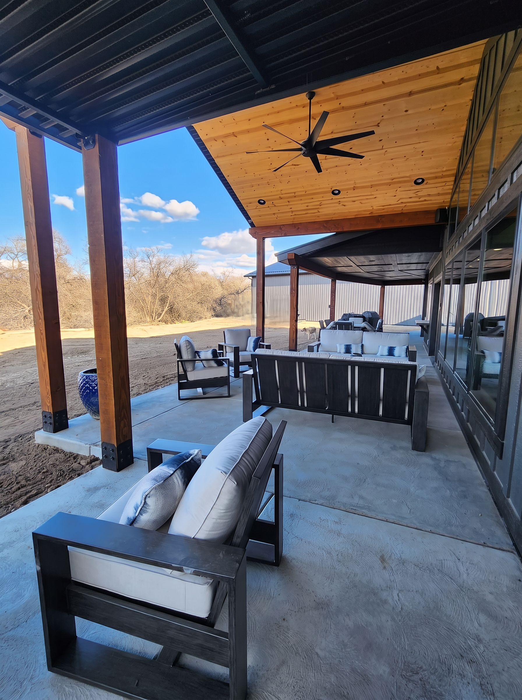 Covered patio with timber posts, wood ceiling, and lounge seating