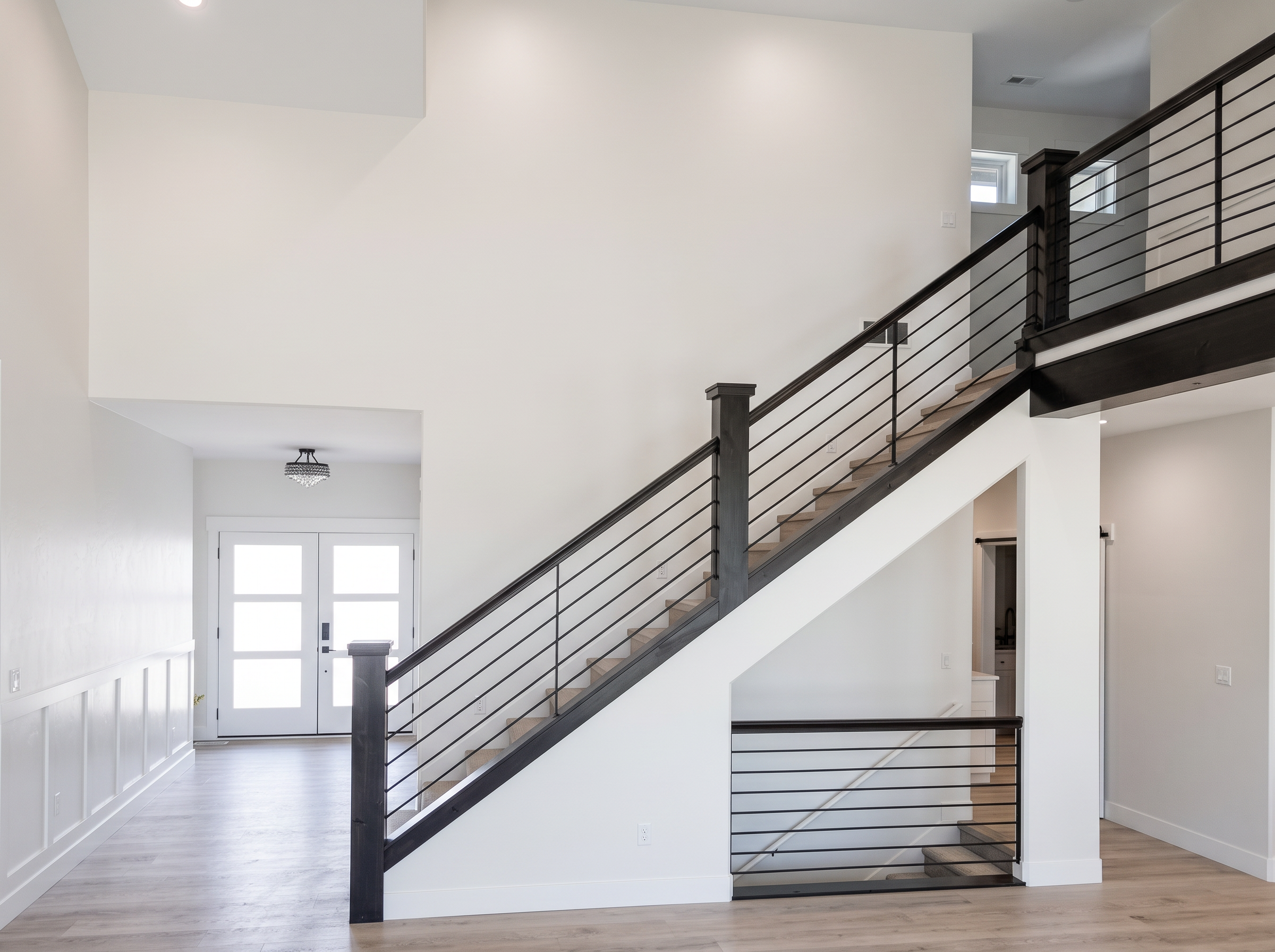 Two-story entry with dark horizontal rail staircase